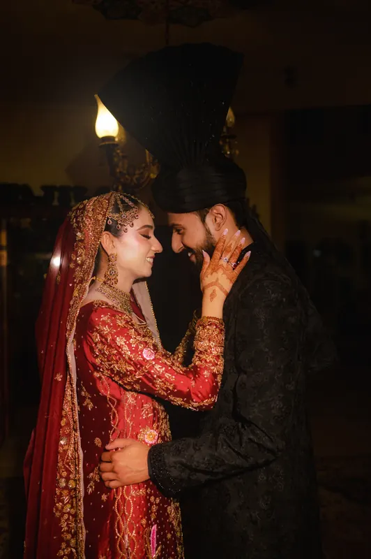 Couple photographed in dramatic candlelight at a wedding in Islamabad, cinematic style by Arsalan Asad
